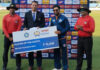 Player of match receiving a cheque from dignitary.