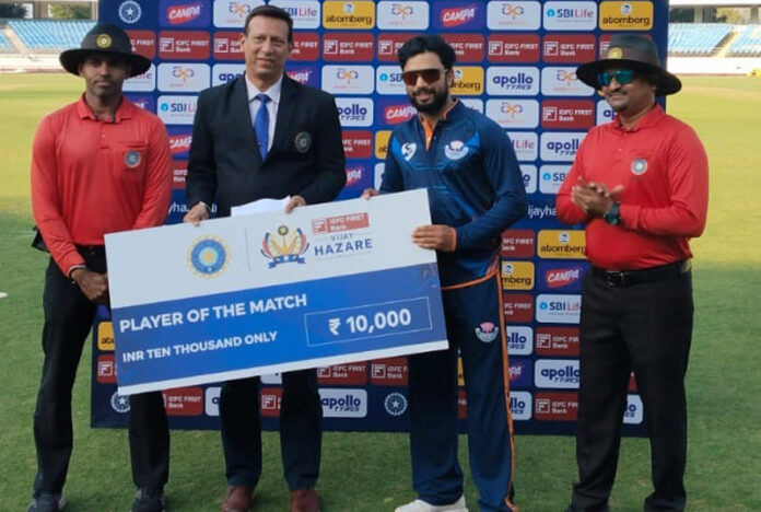 Player of match receiving a cheque from dignitary.