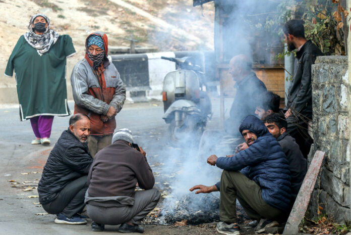 A group of people warm themselves on a roadside as Srinagar shivers. -Excelsior/Shakeel