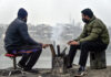 People warm themselves around a fire in Srinagar on Thursday. -Excelsior/Shakeel