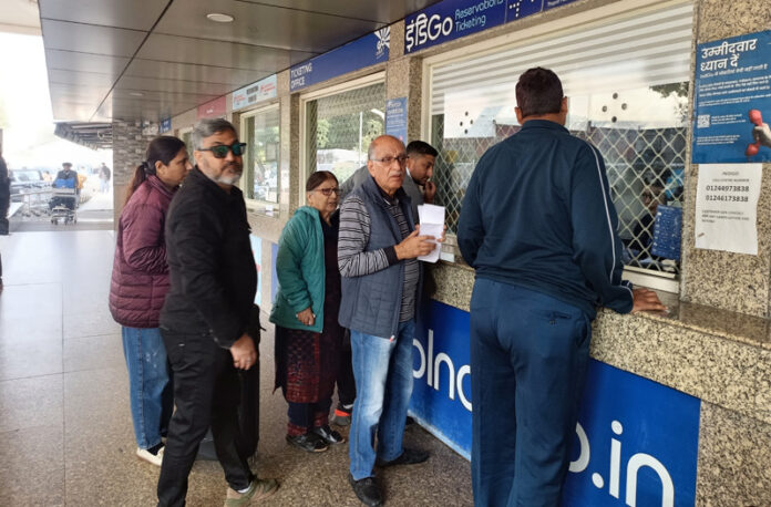 Passengers wait outside the ticket counter after several flights were cancelled at Jammu Airport on Saturday.