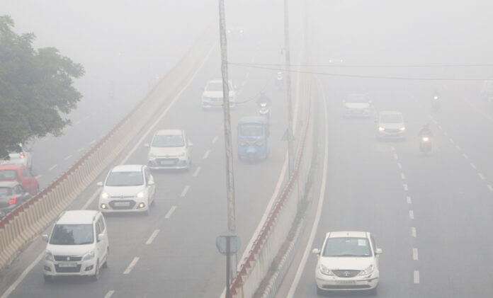 Vehicles with their headlights on, moving through dense fog on a Jammu road. —Excelsior/Rakesh