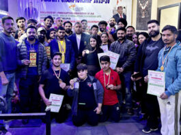 lifters posing along with medals and dignitaries during prize distribution ceremony.