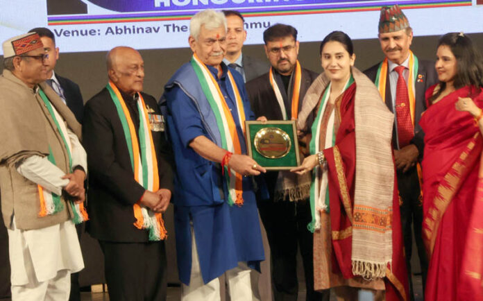 LG Manoj Sinha presenting memento to woman achiever during a programme.