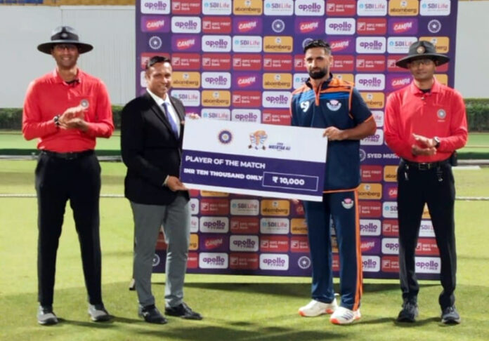 Player of match receiving a cheque from dignitaries.
