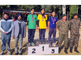 Winners posing on podium along with medals and dignitaries.
