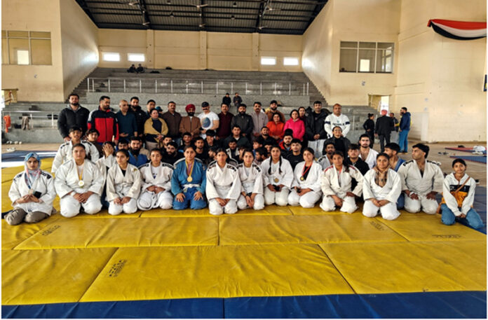 Judo athletes posing along with dignitaries during prize distribution ceremony.