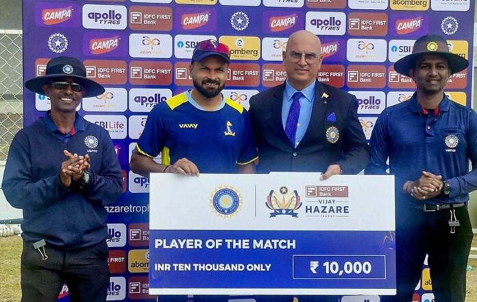 Player receiving man of the match award from dignitaries.
