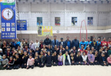 Gymnasts posing along with dignitaries during closing ceremony.