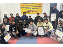 Table Tennis players posing along with certificates and trophies during closing ceremony.