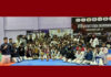 Taekwondo players posing along with medals during prize distribution ceremony.