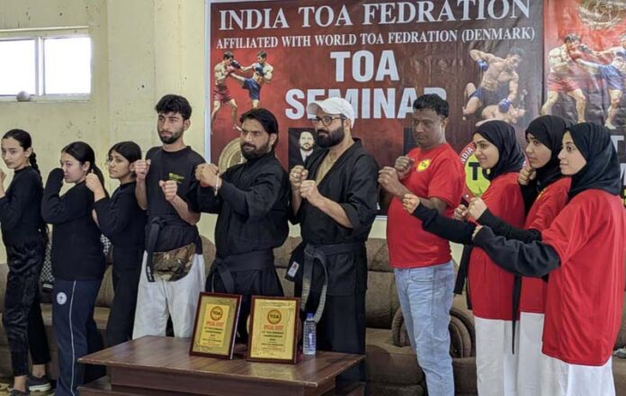 Dignitaries posing along with athletes during a programme.