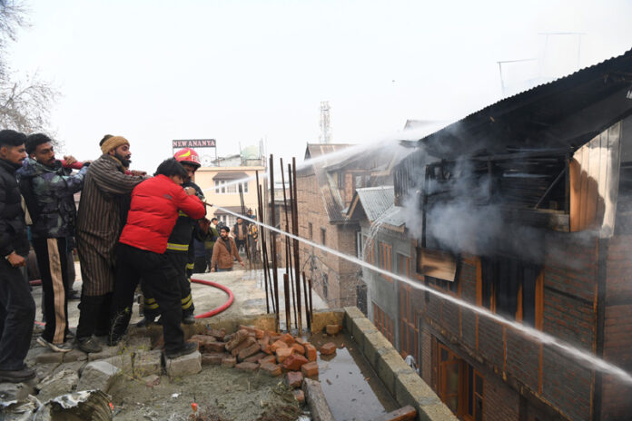 Firefighters dousing flames in Khayam area of Srinagar on Wednesday. -Excelsior/Shakeel