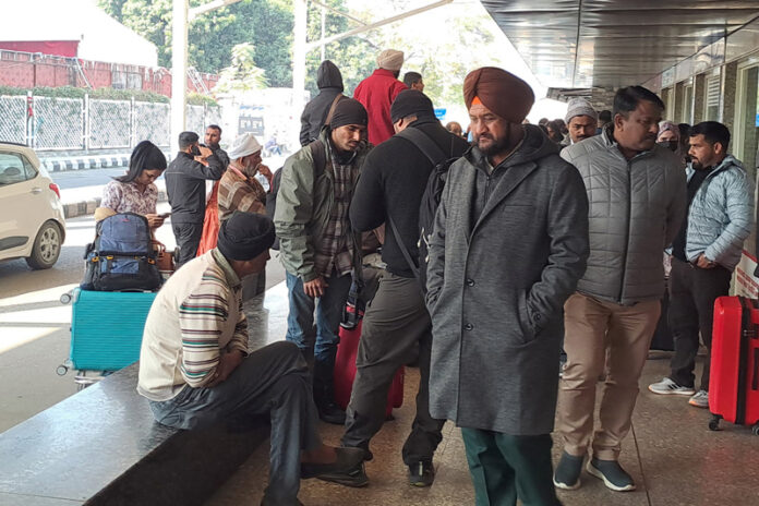Passengers wait outside the IndiGo Airlines' ticket counter after several flights were cancelled, at Jammu Airport on Friday.