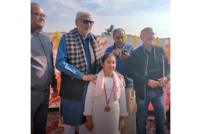 MLA Jammu West , Sham Lal Sharma giving a prize to a girl who participated in the painting competition held by Shree Ram Shaiv Trika Ashram Janipur on Sunday