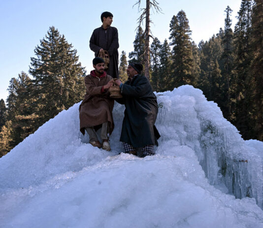 People take selfies at a popular chill point near a naturally formed giant icicle in Goguldara area in Srinagar. -Excelsior/Shakeel