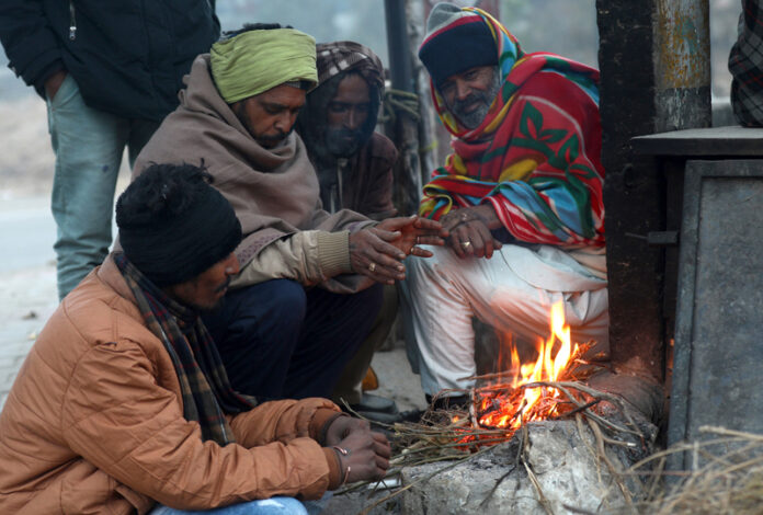 Villagers warm themselves, burning fire to beat the severe cold on the outskirts of Jammu on Thursday morning. -Excelsior/Rakesh