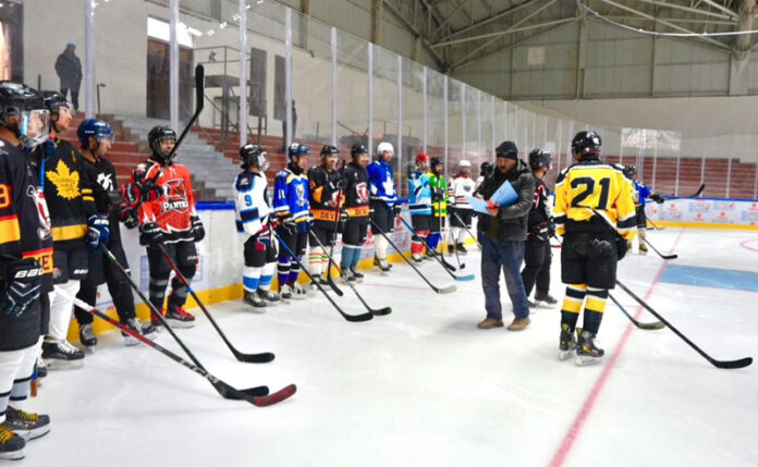 Officials posing along with Ice Hockey players during trials.