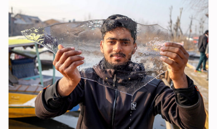 Dal lake’s interior water freezes as Srinagar reels under a biting -6o C on Friday, drawing tourists to enjoy the wintry spectacle. — Excelsior/Shakeel