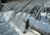 A man walks along a road in Budgam district as icicles hang in the foreground amid sub-zero temperatures. — Excelsior/Shakeel