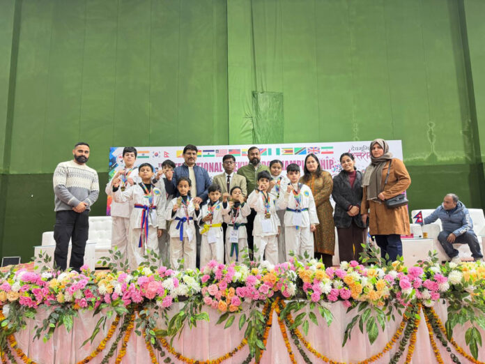 Medal winners posing along with dignitaries during prize distribution ceremony.