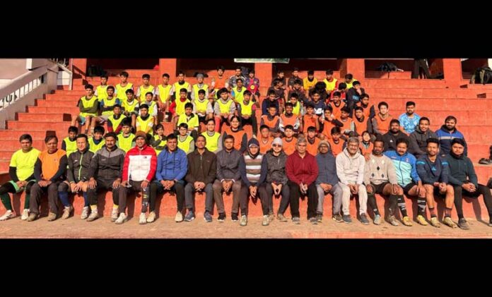 Football players posing along with dignitaries.