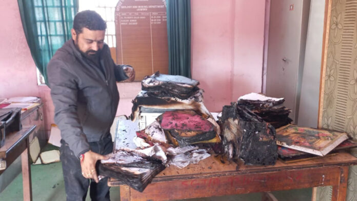 A staff member at DMO Jammu office retrieving files partially damaged in the fire. A staff member at DMO Jammu office retrieving files partially damaged in the fire.