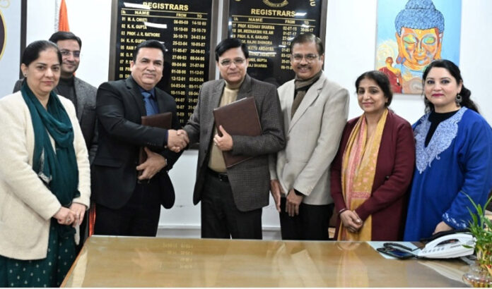 JU Registrar shaking hand with NIELIT representative during signing of MoU.