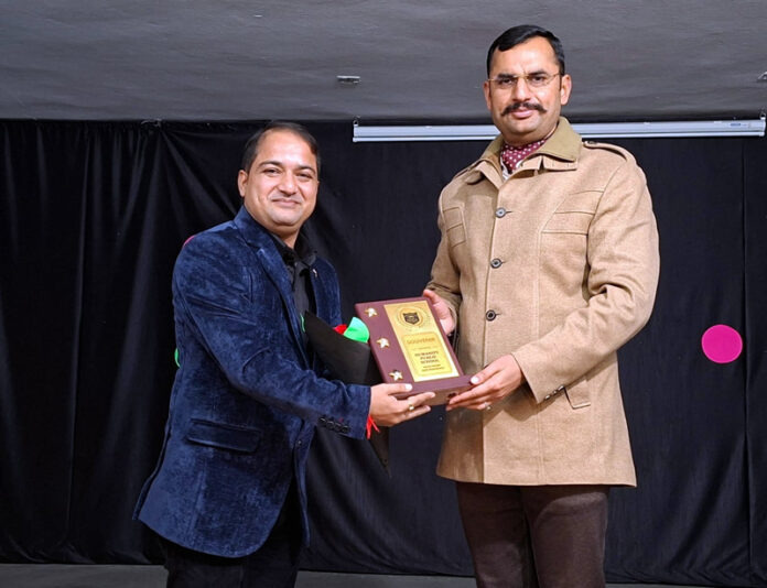 Principal Gaurav Charak presenting memento to Harish Raina.