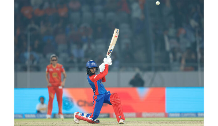 DC player hitting shot during match against Gujarat Giants.