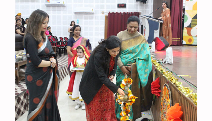 Dignitary lighting traditional lamp during a programme.