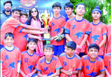 Winning team posing along with trophy.