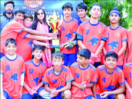 Winning team posing along with trophy.