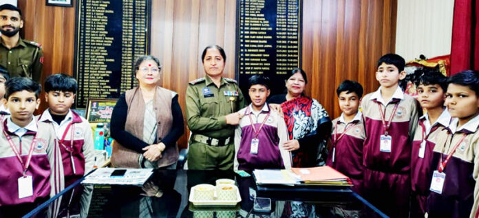 Students posing along with SHO Shakti Sharma during their tour to police station.