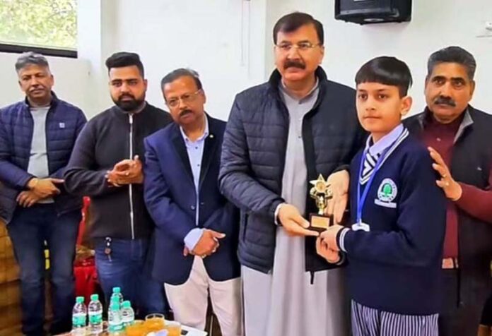 MLA-Jammu West Arvind Gupta presenting trophy to a student.