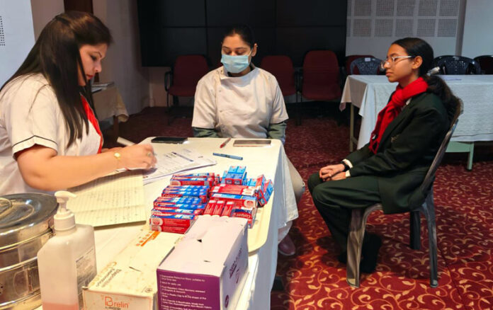 A dentist prescribing medicines to a patient during a dental check-up camp in Jammu.