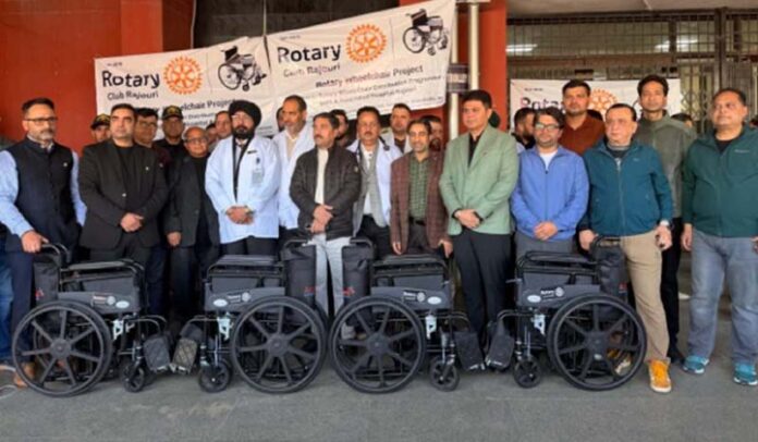 Dignitaries from Rotary Club Rajouri along with others pose for a photograph after distributing wheelchairs to GMC and Associated Hospital Rajouri.