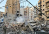 A man walks past debris at the site of an overnight Israeli airstrike in Beirut’s southern suburb of Bir al Abed on Tuesday.