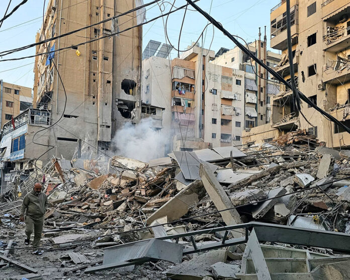 A man walks past debris at the site of an overnight Israeli airstrike in Beirut’s southern suburb of Bir al Abed on Tuesday.