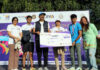 Dignitaries presenting winner’s cheque to a runner at prize distribution ceremony.
