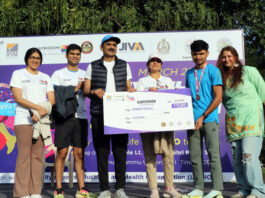 Dignitaries presenting winner’s cheque to a runner at prize distribution ceremony.