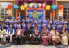 Dignitaries posing along with students during a programme.