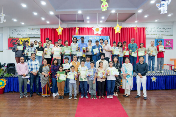 Winners posing with trophies and certificates along with dignitaries.