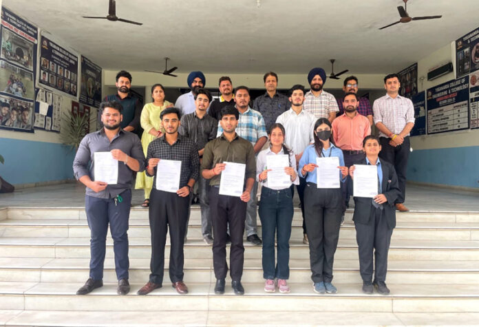 Selected students posing along with placement orders along with dignitaries during a programme.