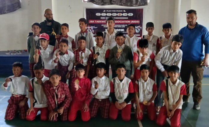 Taekwondo players posing along with organisers during a programme.