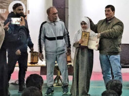 A player posing along with dignitary during prize distribution ceremony.