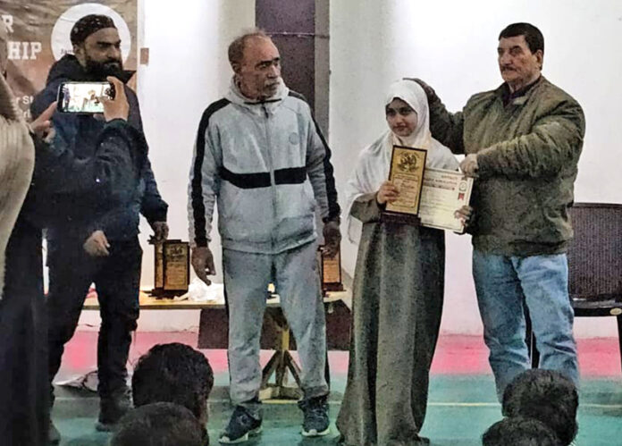 A player posing along with dignitary during prize distribution ceremony.