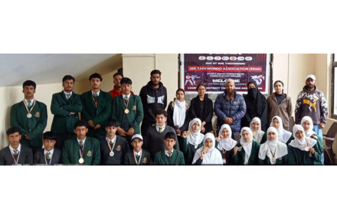 Taekwondo players posing along with dignitaries during closing ceremony.