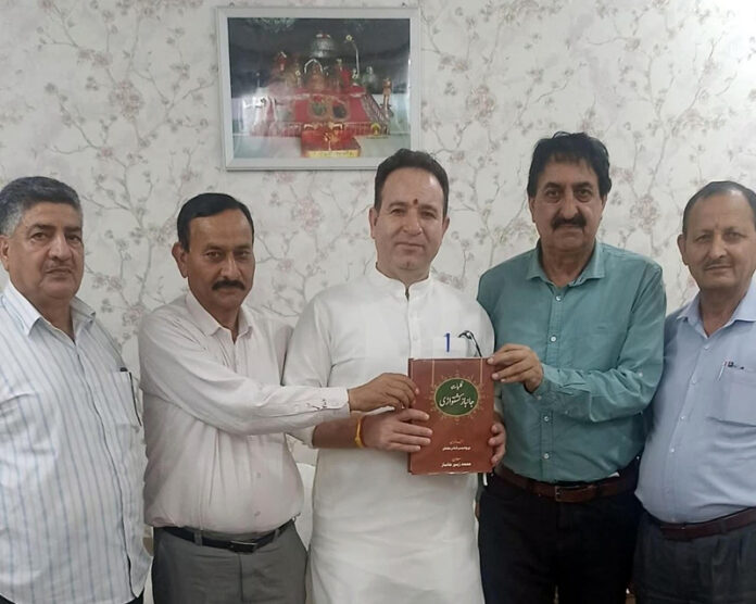 Zubair Doolwal presenting Kulliyat-e-Janbaz to LoP Sunil Sharma at Jammu on Wednesday.