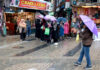 Shoppers move with umbrellas through a rain-soaked market in Srinagar city on Wednesday. -Excelsior/Shakeel